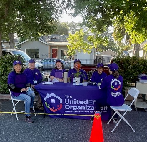Six United Effort volunteers sit around a branded table